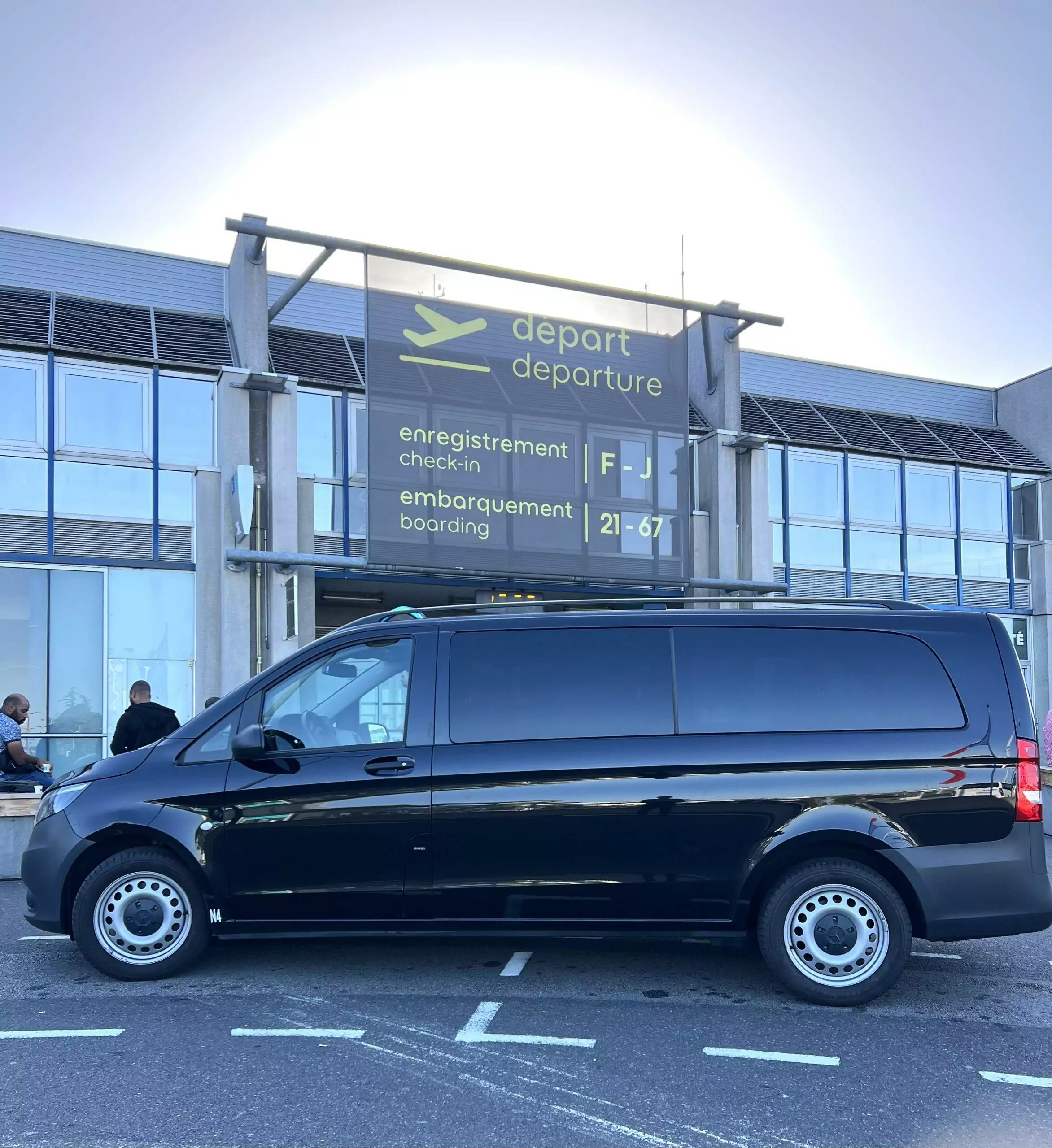 an noir haut de gamme pour transferts de groupes devant le terminal départs de l'aéroport Nantes Atlantique. Service logistique premium coordonné par l'Agence Helper, DMC bilingue expert en Loire-Atlantique